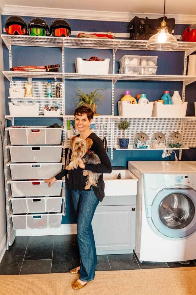 woman holding a Yorkshire terrier in blue laundry room